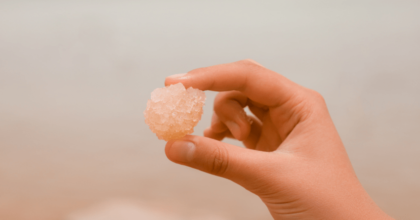 a Piece of pink salt holding in human hand